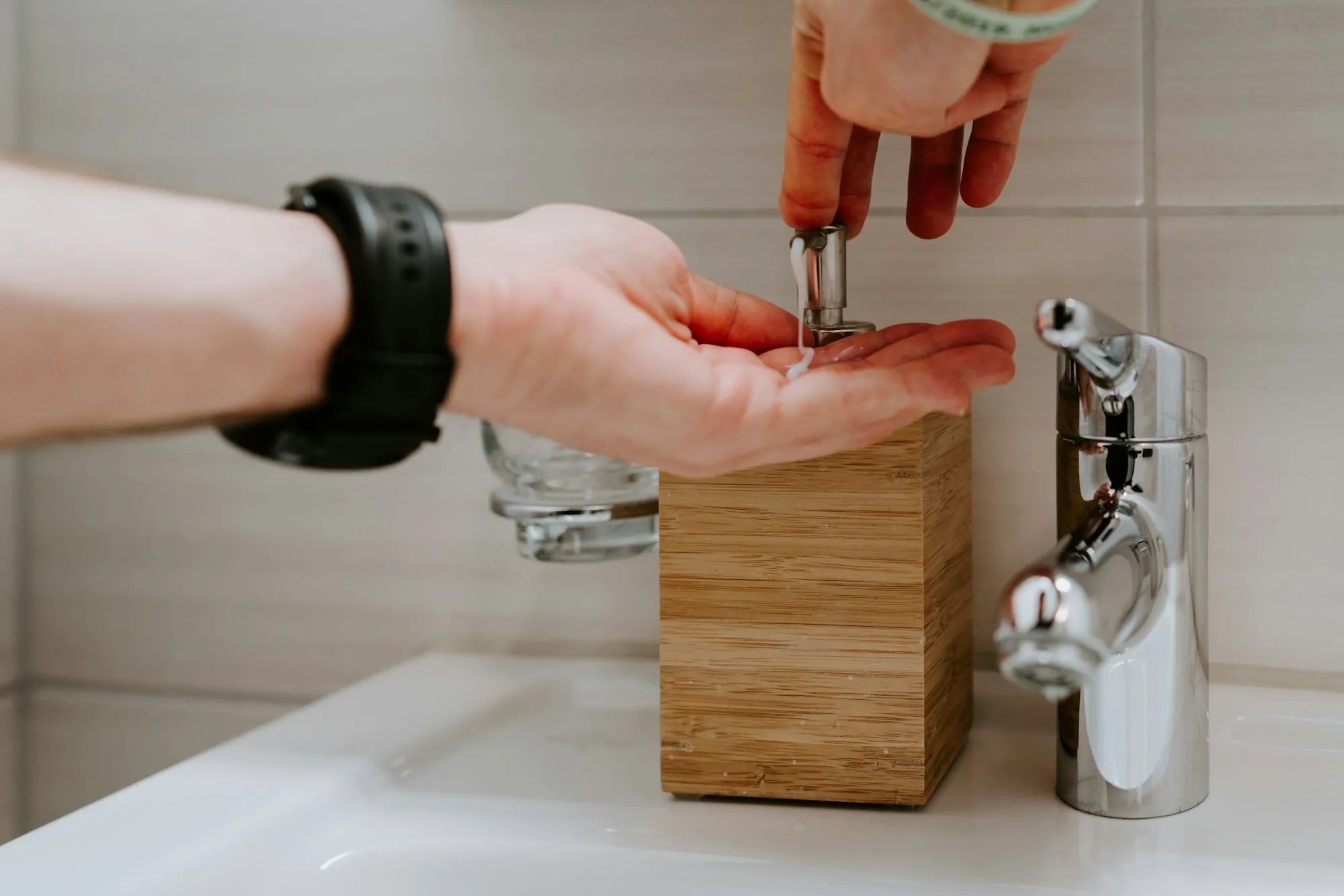 Hand adjusting a stainless kitchen faucet