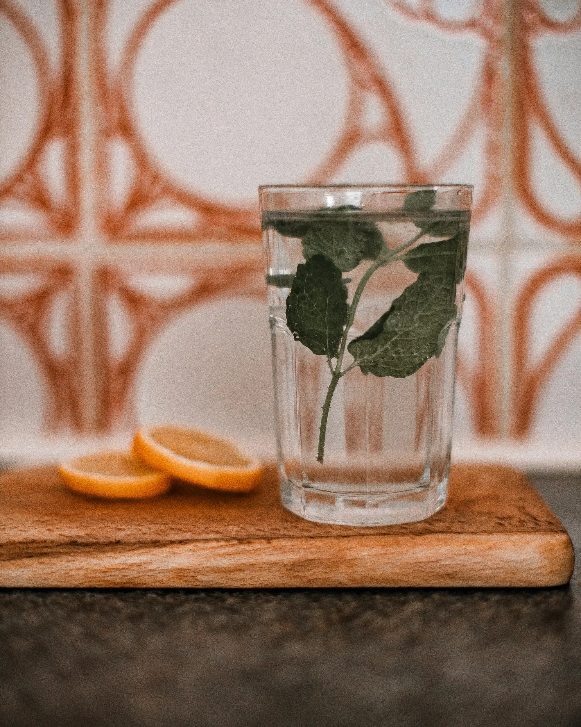 Glass of water with lemon on a wooden board