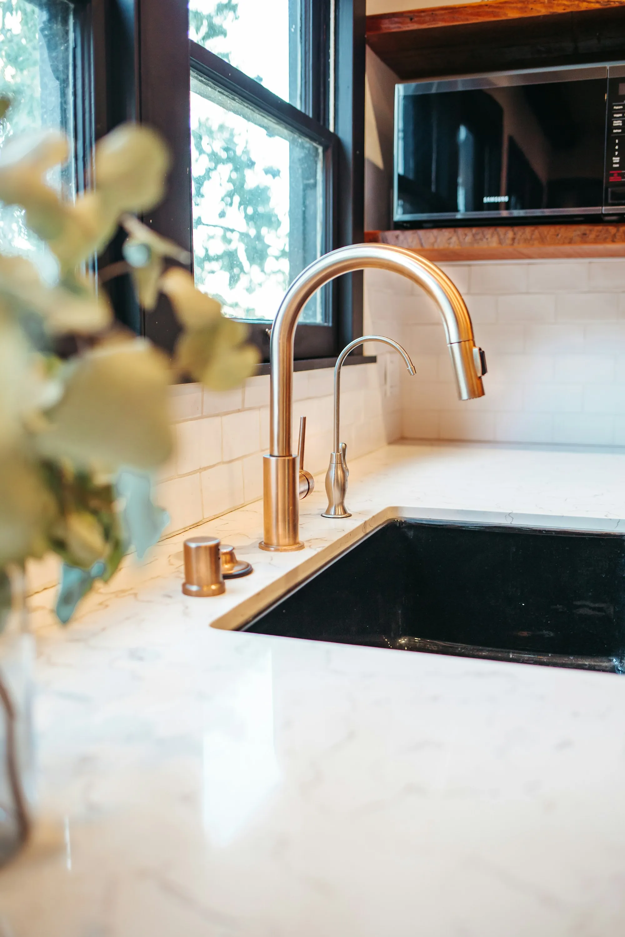 Kitchen sink with a brass faucet and stone counter
