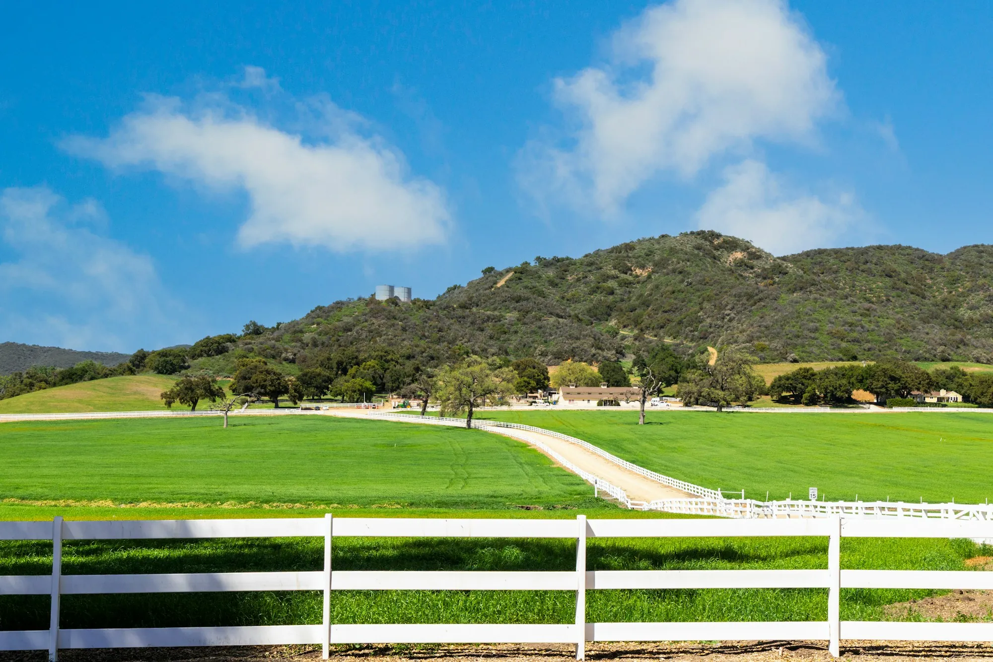 Open ranch land with a fence and rolling hills