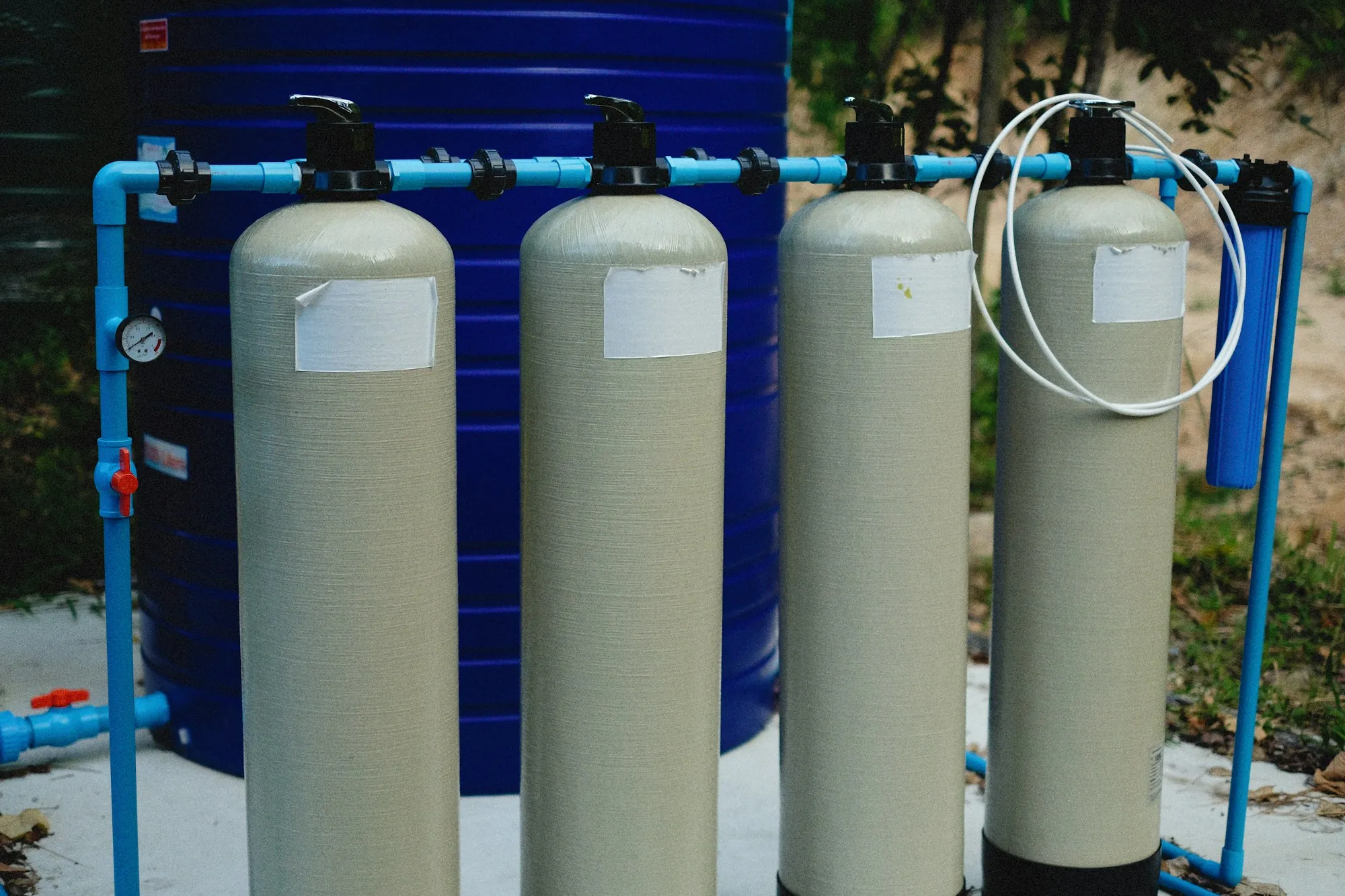 Filtration tanks plumbed together with blue piping